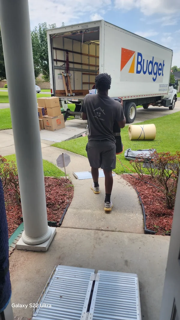 Next Nest team member carrying an item toward a moving truck