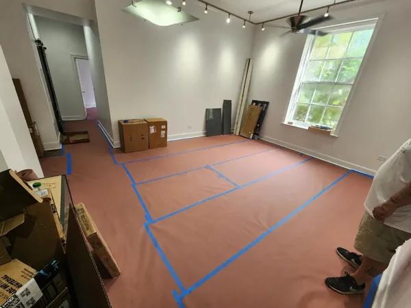 Floor protection secured with blue tape inside a room