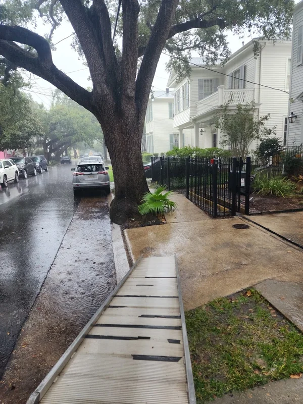 Moving ramp positioned at a sidewalk outside a home on a rainy day