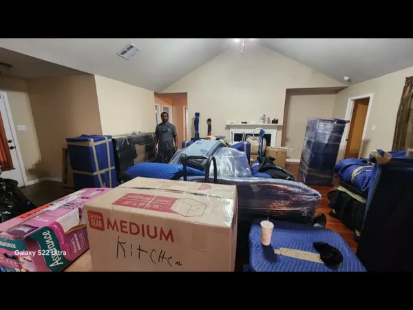 Packed boxes and blanket-wrapped furniture prepared inside a living room