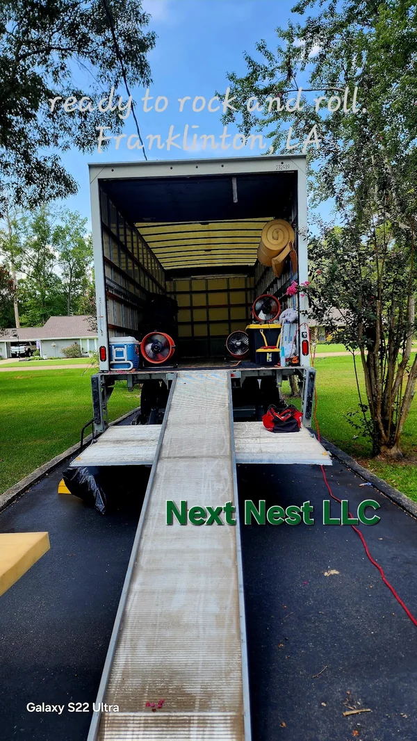 Moving truck and ramp with Next Nest LLC lettering on the photograph