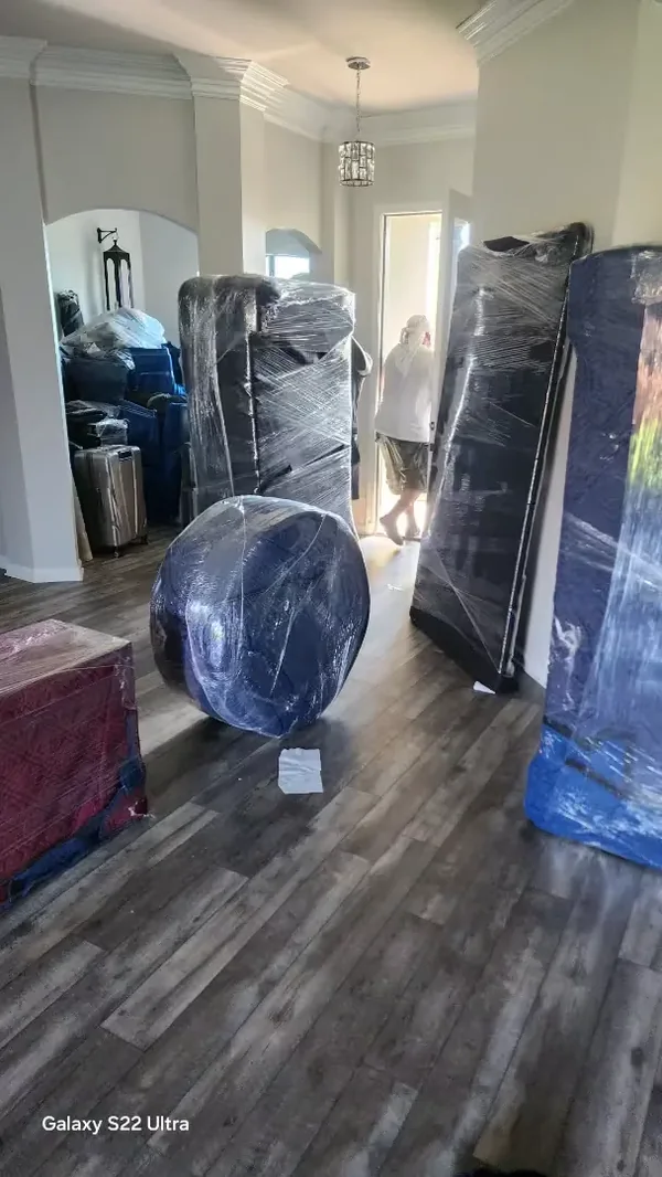Furniture protected with moving blankets and stretch film in a foyer
